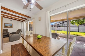 A dining area with a wooden table, chairs, and a ceiling fan. - Pet-Friendly Home | Located in Isles of Capri (Naples)
