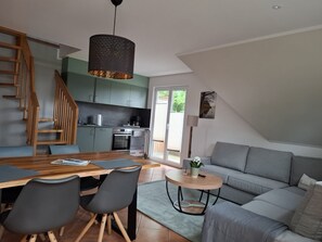 A modern loft with a dining area, kitchen, and living space.