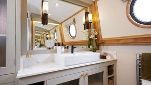 A modern bathroom with a large mirror, a white sink, and a towel rack. - Schwimmendes Wohnboot in Berlin (Berlin)
