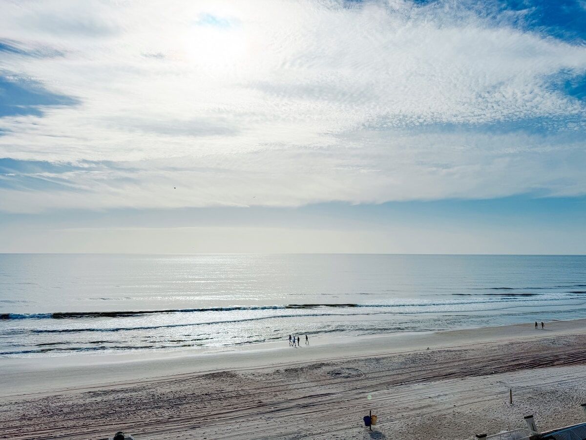 Une plage avec un ciel dégagé et une mer calme.