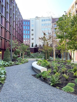 A landscaped pathway with a curved bench, surrounded by greenery and buildings. - Unique Luxury and Quiet in Porto’s Best Location (Porto)