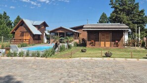 A resort with wooden cabins, a swimming pool, and a paved driveway. - Cabins in Torres, RS, offering leisure and relaxation in a cozy and peaceful location. (Torres)