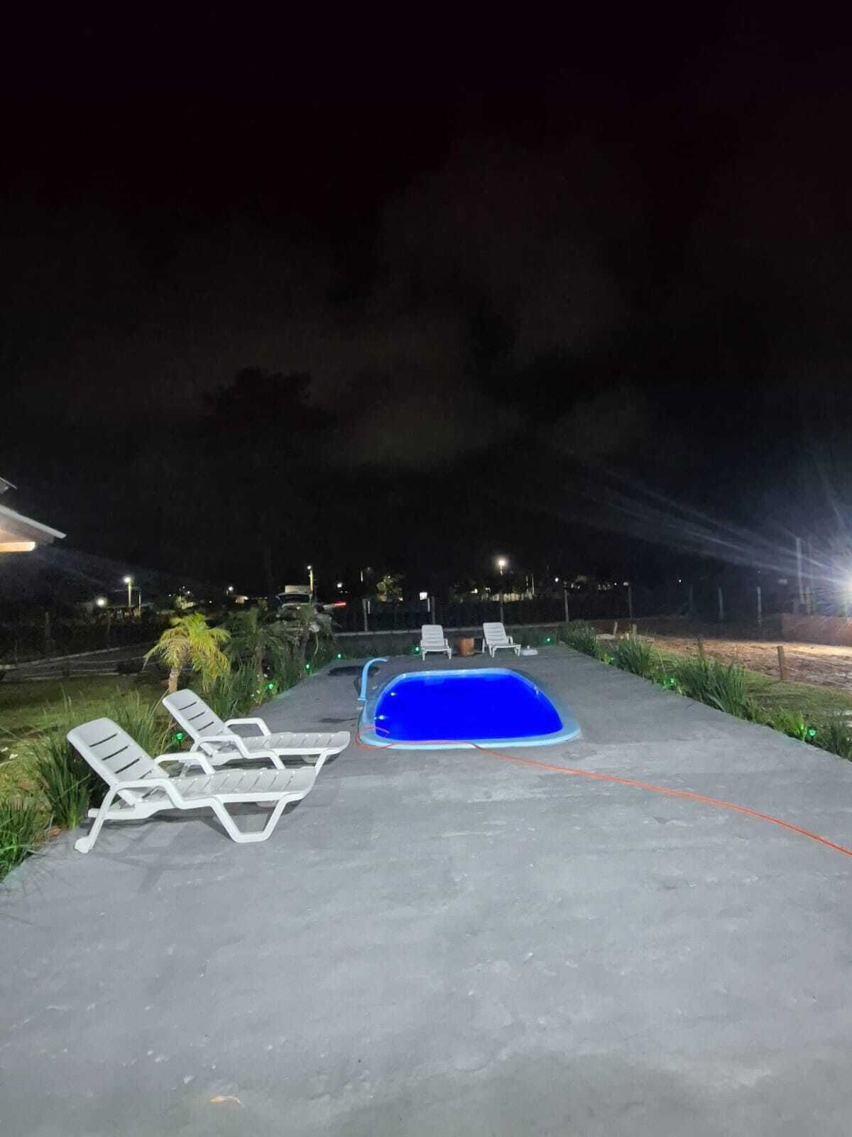 Una piscina al aire libre con sillas de descanso y solárium de hormigón.