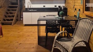 A cozy kitchen with wooden walls and a dining area with wicker chairs. - Cabins in Torres, RS, offering leisure and relaxation in a cozy and peaceful location. (Torres)