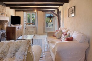 A cozy living room with a sofa, a television, and a fireplace.