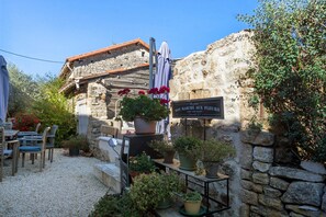A rustic stone building with a sign indicating a flower shop.