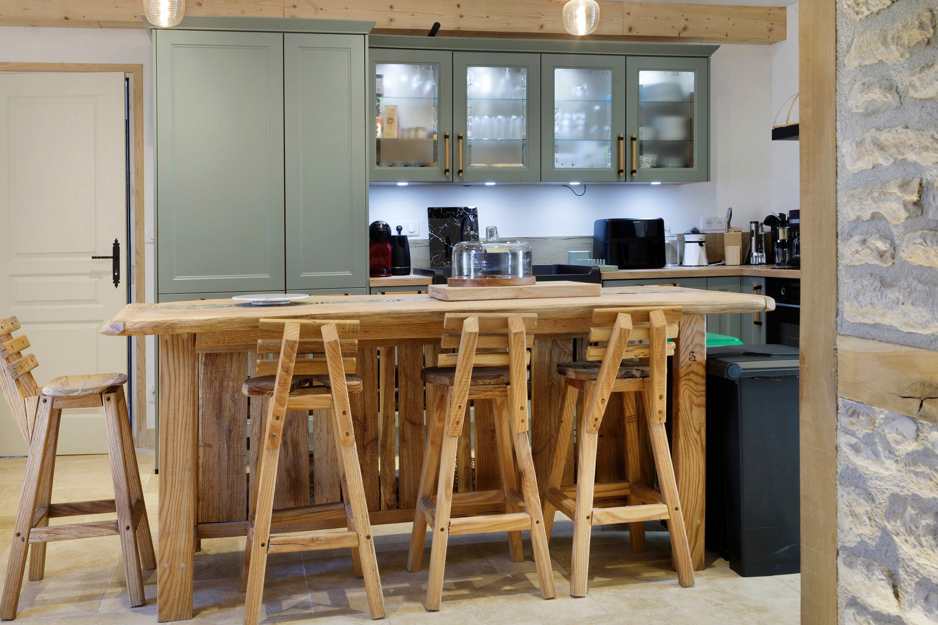 A kitchen with a wooden island, cabinets, and various appliances.