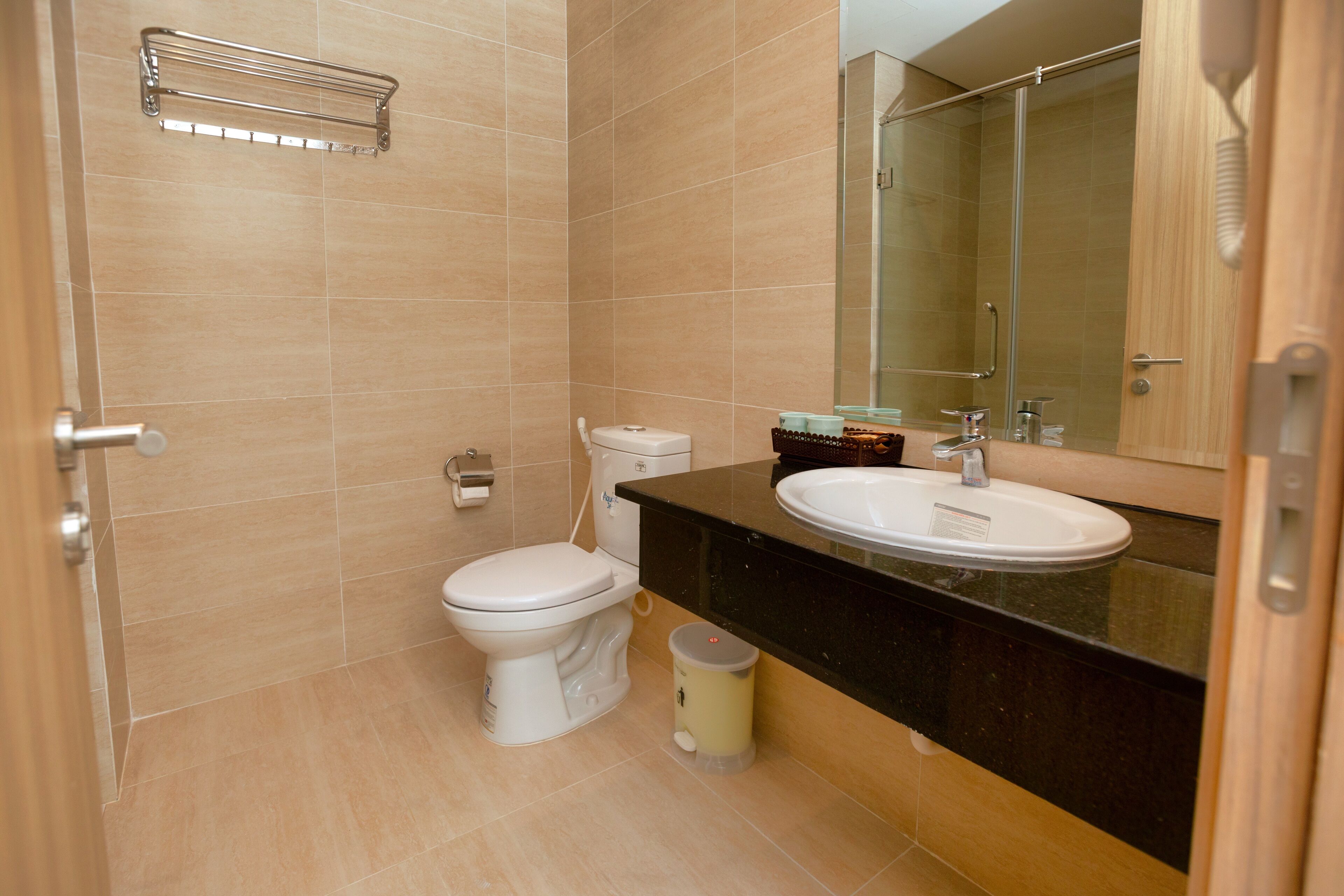Un baño moderno con inodoro, lavamanos y espejo.