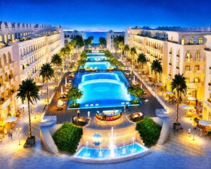 A hotel with a central swimming pool, palm trees, and a fountain. - Cosi Beach Hotel Phu Quoc (Phu Quoc)