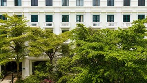 Un immeuble à plusieurs étages, doté d’une façade symétrique, de fenêtres régulièrement espacées et d’une entrée centrale.