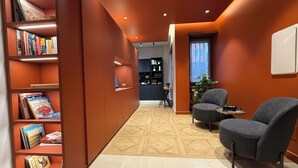 Ein modernes Interieur mit Bücherregal, Sitzecke und Schreibtisch.