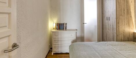 Ein Schlafzimmer mit Bett, Kommode und Tür.
