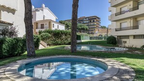 Un patio con piscina, árboles y edificios residenciales.