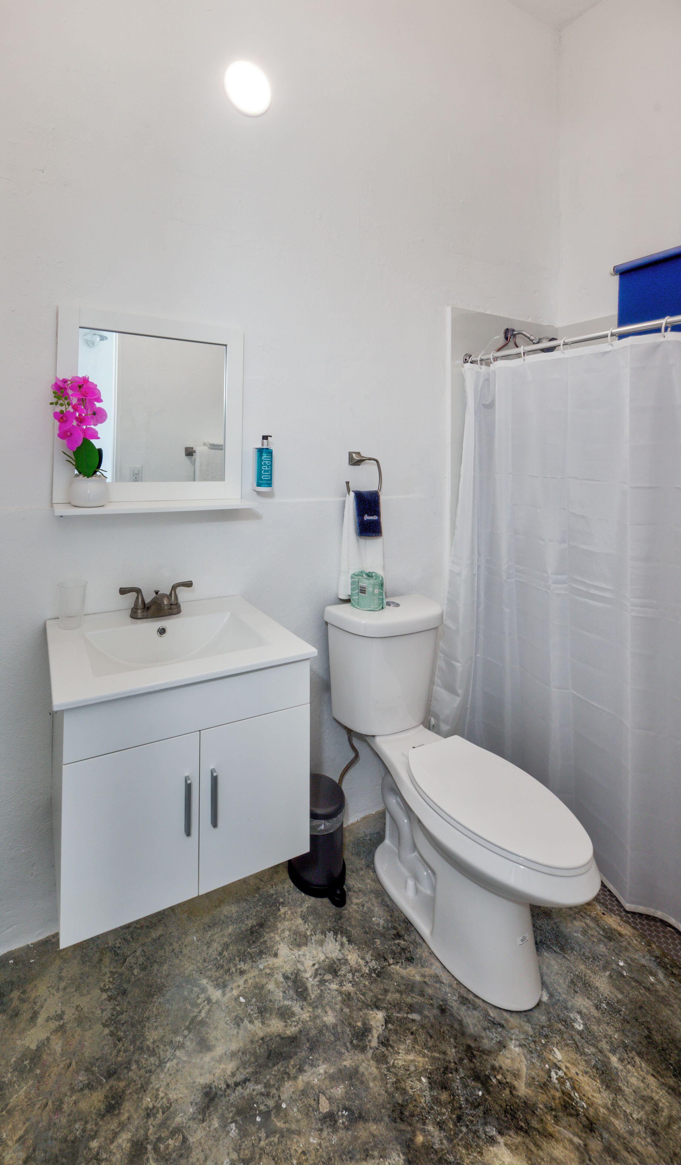 A bathroom with a white sink, toilet, and shower curtain.