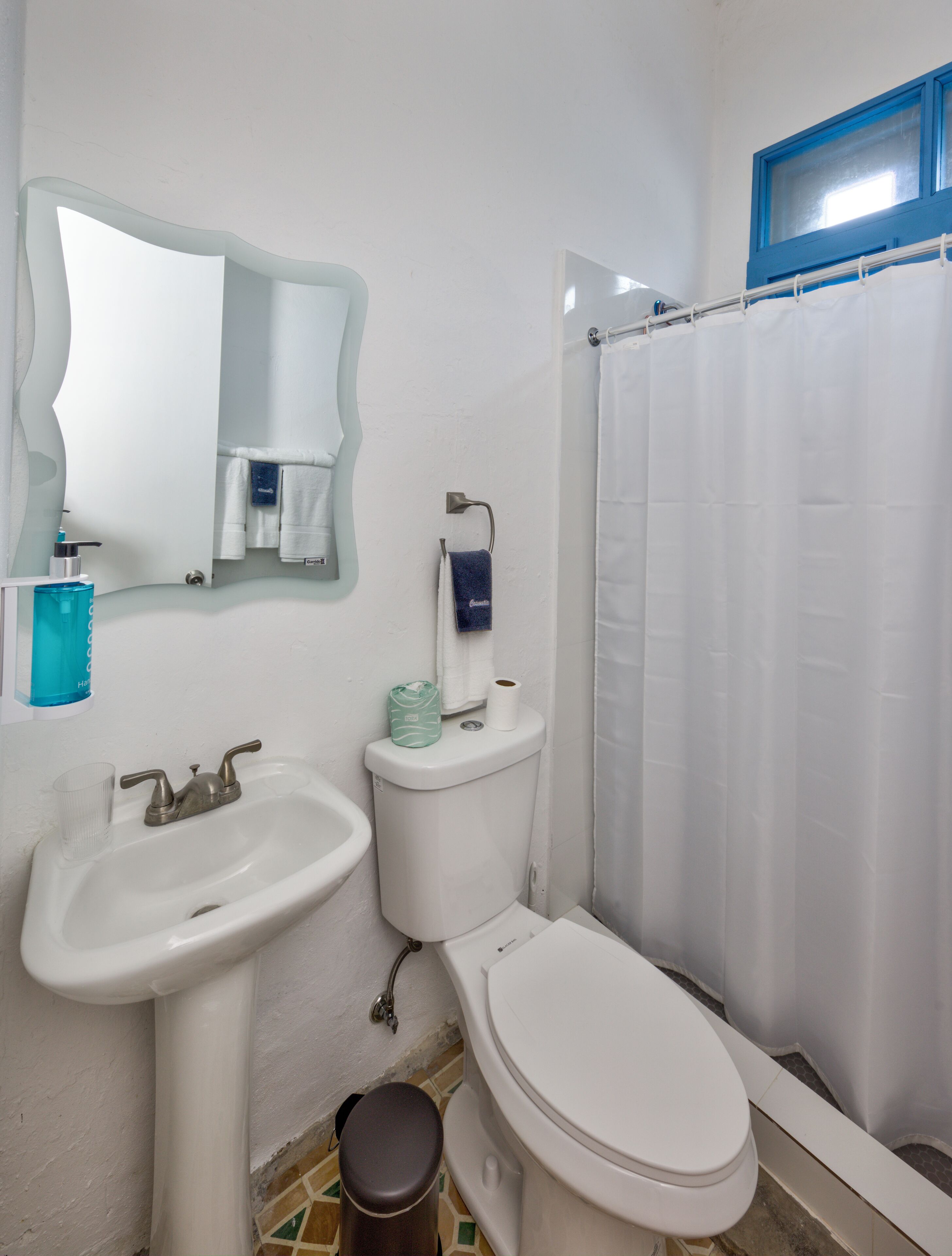 A bathroom with a sink, toilet, and a shower curtain.