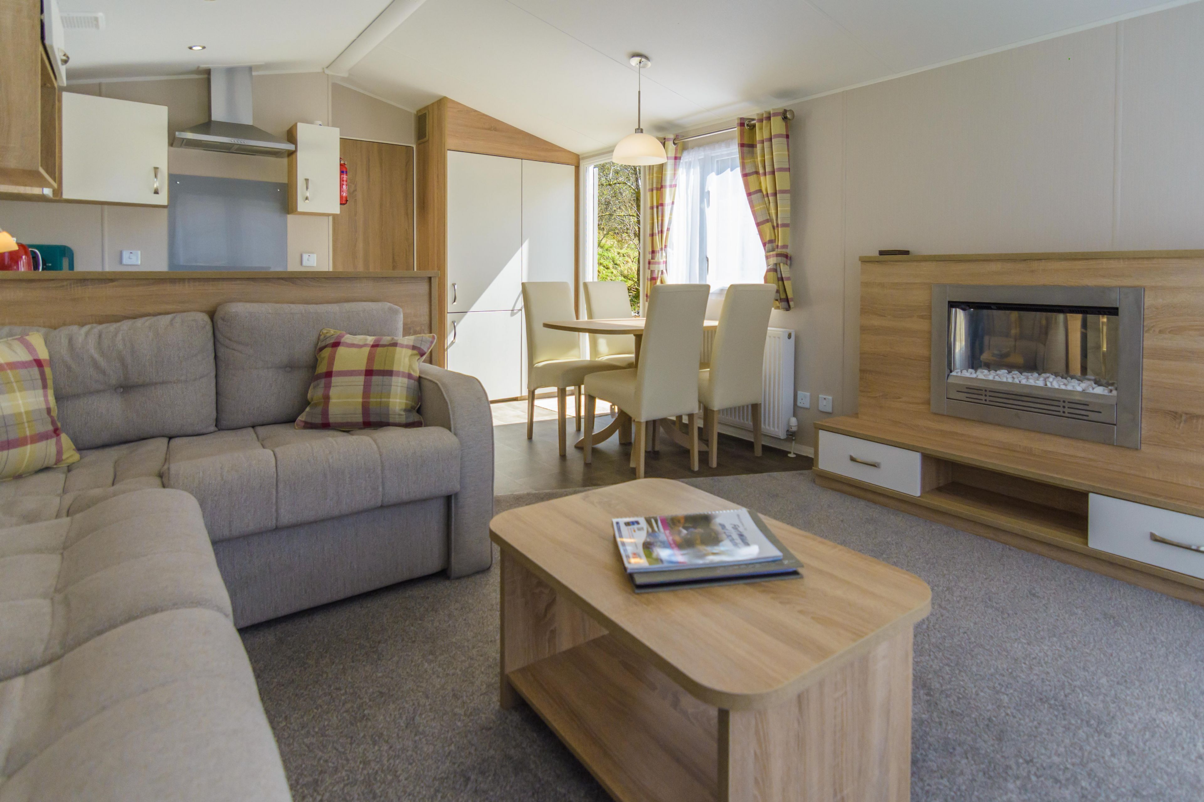 Una sala de estar moderna con un sofá, una mesa de centro, una chimenea y un comedor.