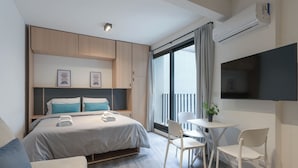 A modern hotel room with a bed, bedside tables, a TV, and a balcony with curtains. - MOT Design SohoHaus (Buenos Aires)