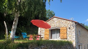 A stone building with a red umbrella, a wooden door, and a window with shutters. - A haven of peace in Rochepaule, in the heart of Ardèche verte (Rochepaule)