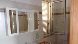 A bathroom with a white sink, mirror, and toilet. - Beachfront penthouse with panoramic terrace and direct beach access (Capo d'Orlando)