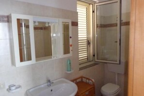 Ein Badezimmer mit Waschbecken, Spiegel und Toilette.