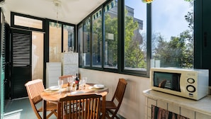 Un comedor con una mesa para dos, microondas y vistas al exterior.