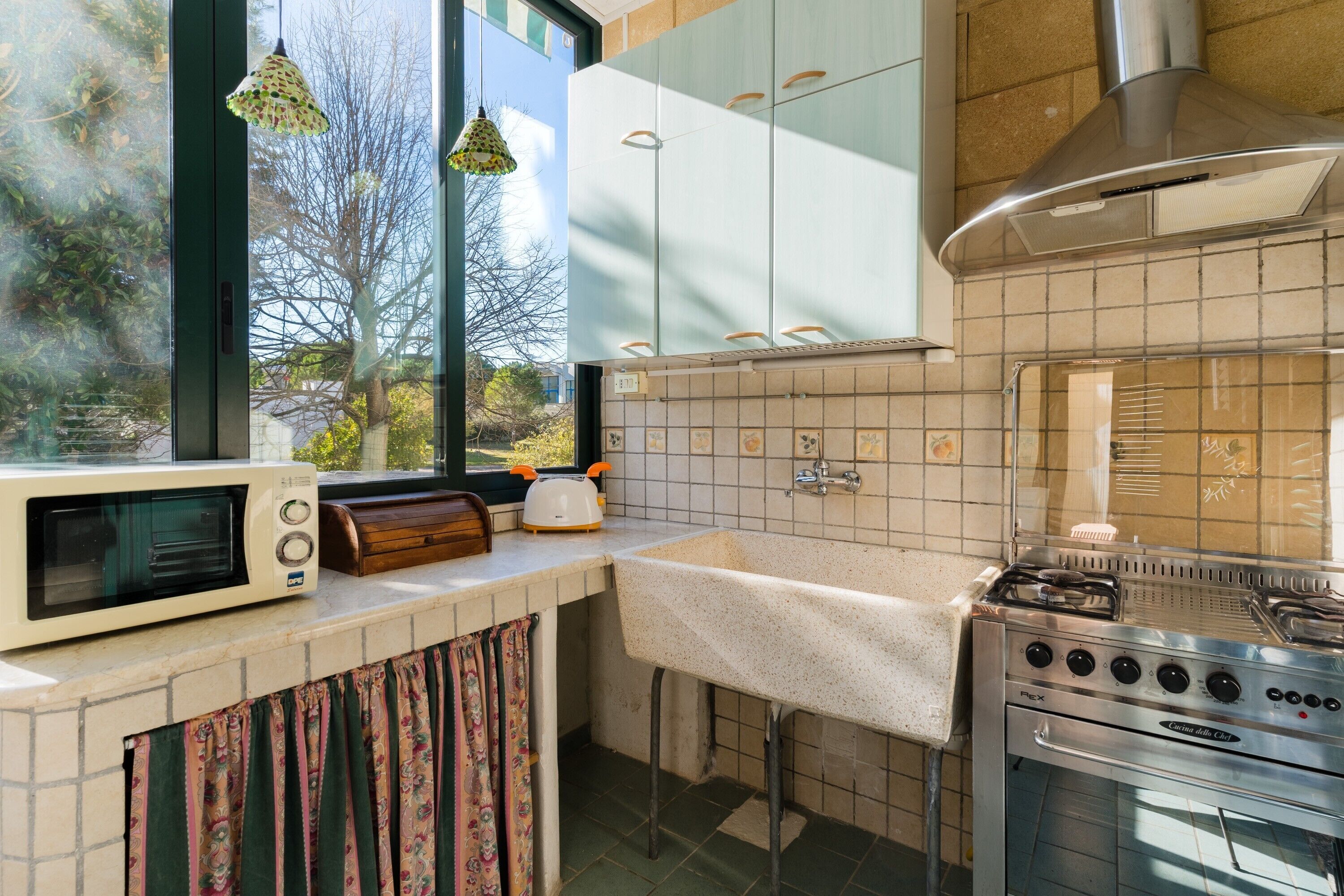 Una cocina con microondas, tostadora, lavabo y estufa.