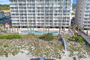 A multi-story hotel with balconies, a pool area, and a beach view. - Crescent Shores #1607S - Oceanfront 3BD - Indoor/Outdoor Pools (North Myrtle Beach,)