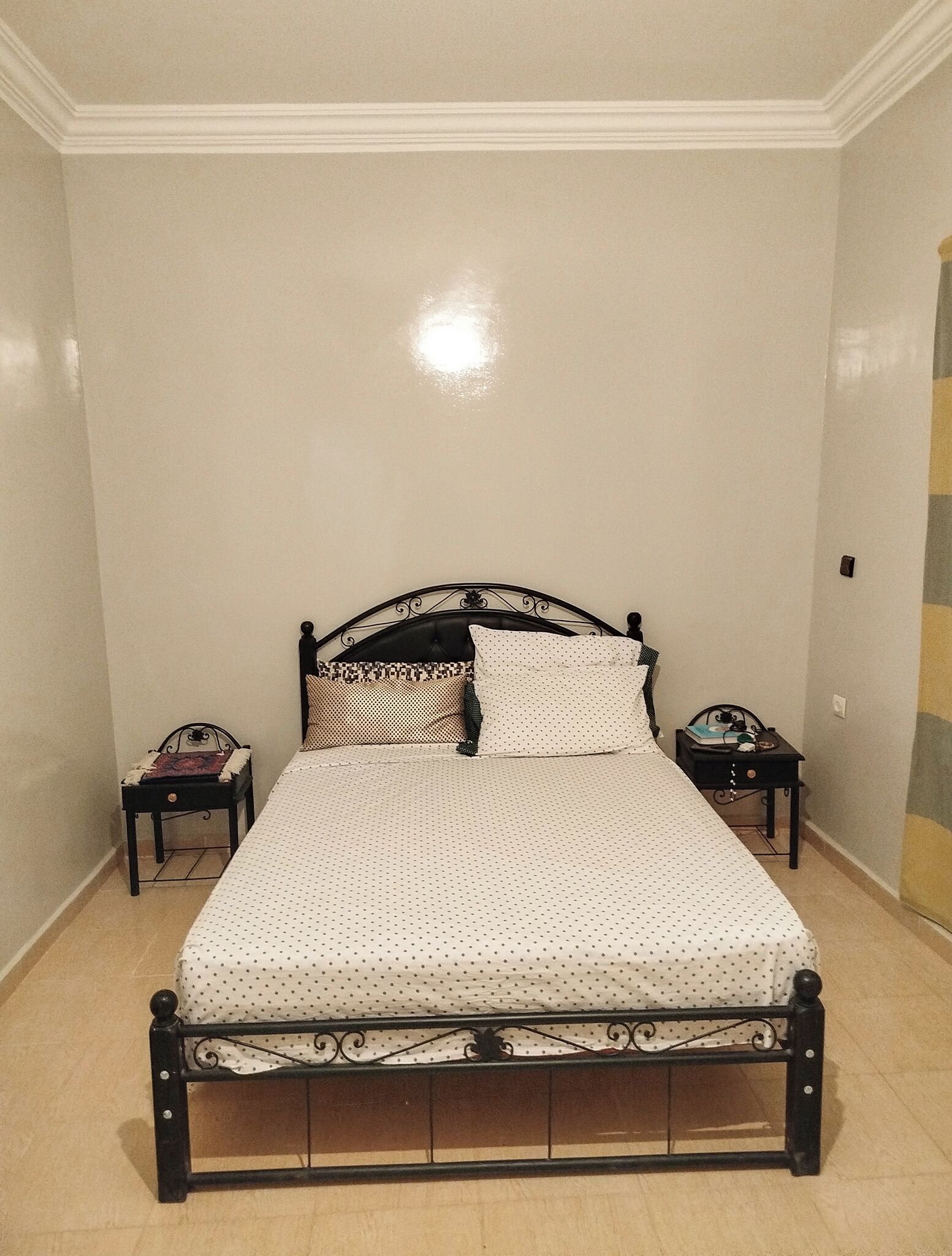 Ein Schlafzimmer mit einem Bett, zwei Nachttischen und einer Wand mit einer Dekoration.
