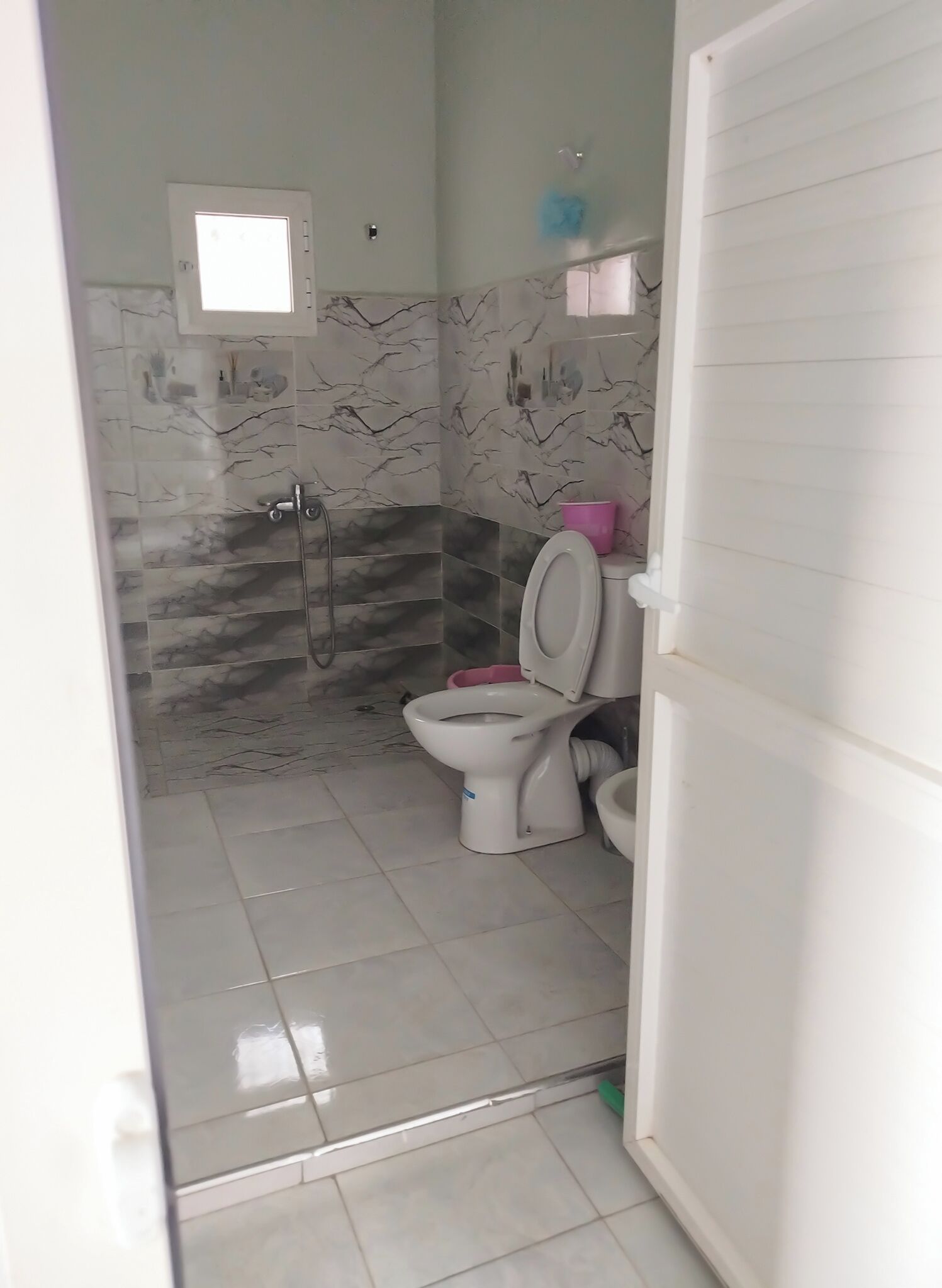 Ein Badezimmer mit Toilette, Bidet und Dusche.