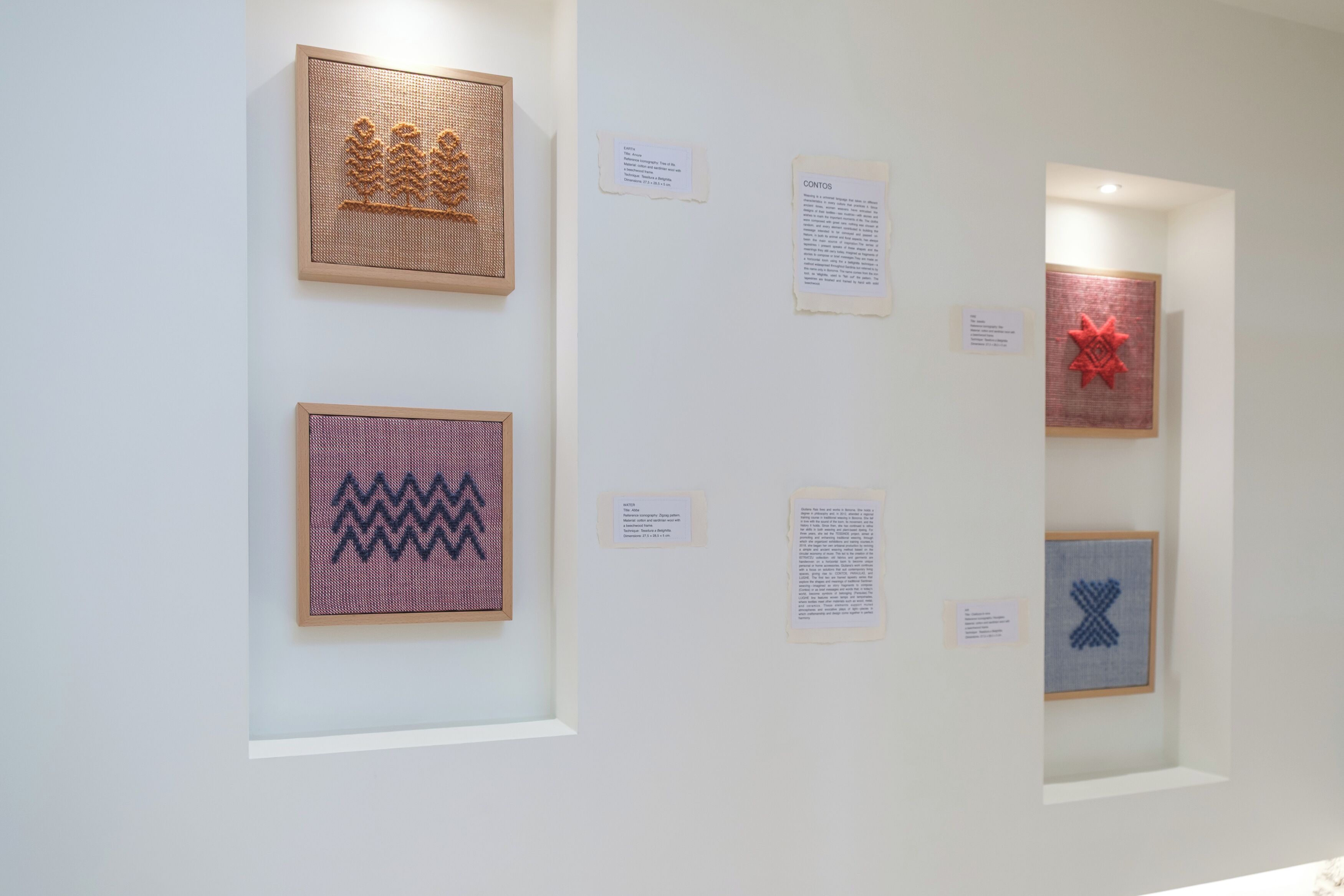 Een galerij met ingekaderde kunstwerken, waaronder geometrische patronen en een ontwerp dat op een rode ster lijkt.