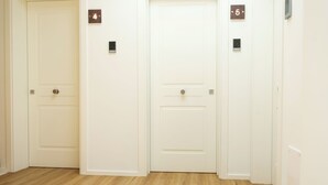 A hallway with three doors, numbered 4, 5, and another door on the right.