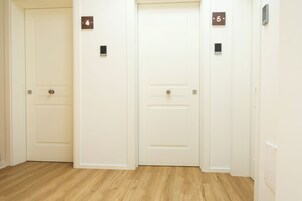 Un couloir avec trois portes, numérotées 4 et 5, et une autre porte sur la droite.