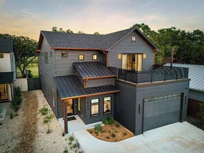 A modern two-story house with a garage, a covered patio, and a small garden area. - Mstr dwn! Pool, DiscGolf, ZipLine, FirePit (Canyon Lake)