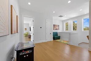 A spacious room with a wooden floor, a green sofa, and a painting on the wall. - Mstr dwn! Pool, DiscGolf, ZipLine, FirePit (Canyon Lake)