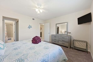 A bedroom with a bed, a dresser, a mirror, and a TV. - Fair Seas Clipper - Pet Friendly and Near Beach (St. Augustine)