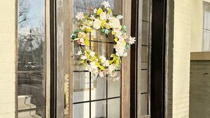 Une porte en bois avec un panneau de verre et une guirlande, portant le numéro 322.
