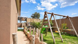 A wooden swing set and a ladder in a grassy outdoor area with a building in the background. - Villa 10 people with swimming pool - Lecci (Lecci)