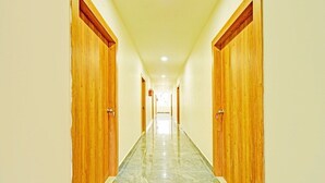 A hallway with wooden doors and a marble floor.