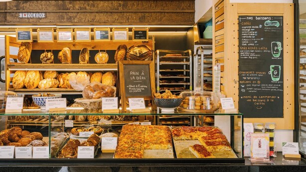 Una vetrina di panetteria con diversi tipi di pane e dolci.