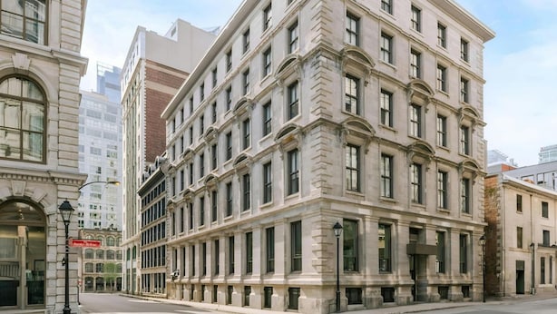 Un edificio de varios pisos con estilo arquitectónico clásico, que cuenta con grandes ventanales y una fachada simétrica.