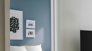 Un dormitorio con cama, escritorio y televisor.