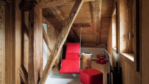 A wooden interior with a red sofa, a wooden ceiling, and a radiator. - Luxury Chalet with Private Sauna and Gym (Cortina d'Ampezzo)