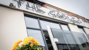 Un bâtiment sur lequel on peut lire l’inscription : « The Cabal ».