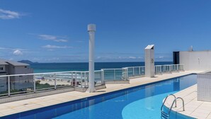 A rooftop pool with a clear view of the ocean and beach. - Apartment With BBQ in Condo With Pool Eaf0404 (Florianópolis)