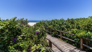 A wooden boardwalk leading to a beach with a clear blue sky. - Apartment With BBQ in Condo With Pool Eaf0404 (Florianópolis)