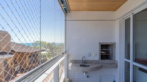 A balcony with a view of a brick building and a clear sky. - Apartment With BBQ in Condo With Pool Eaf0404 (Florianópolis)