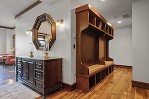 A wooden bench with a cushioned seat and backrest, a large mirror with a hexagonal frame, and a dark wooden cabinet with drawers and a lamp on top. - NEW! Ski in/Ski Out Mid-Mountain Getaway (Park City)