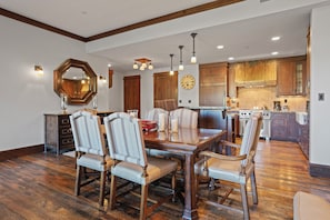 A dining room with a wooden table and six upholstered chairs, a large mirror, and a clock on the wall. - NEW! Ski in/Ski Out Mid-Mountain Getaway (Park City)
