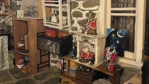 A rustic room with stone walls, wooden shelves, and a variety of kitchen items. - Enjoyable 1-bedroom bed & breakfast in charming Naggar (Naggar)