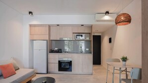 A compact kitchen with modern appliances, a dining area with a table and chairs, and a sofa with cushions. - MOT Rentals + Black Ravignani 1A - 3 pax Loft Palermo Hollywood (Buenos Aires)